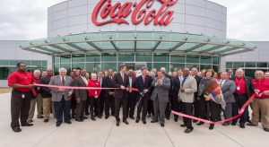 crowd of people cutting a ribbon in front of chattanooga coca cola headquarters