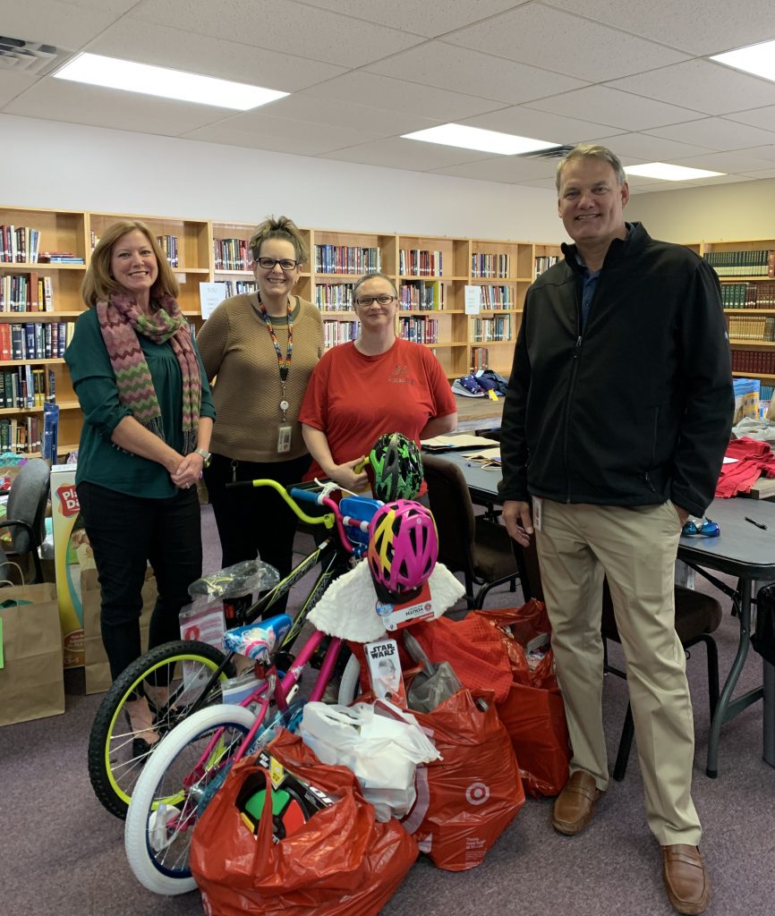 4 people with donated bikes and toys