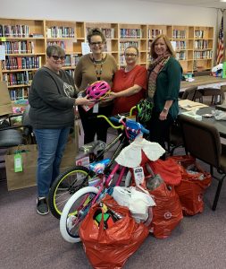 4 people with donated bikes and toys