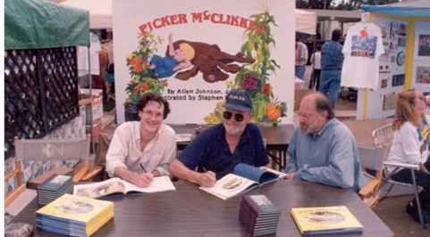 two people at a table signing books